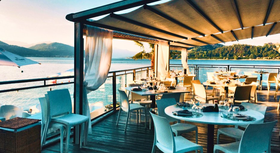 Sunset over a lakeside restaurant terrace, the cover of a saved restaurant card